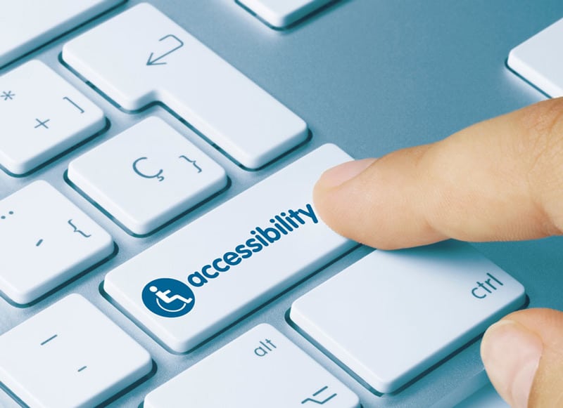 Keyboard with a finger pushing a key that reads accessibility